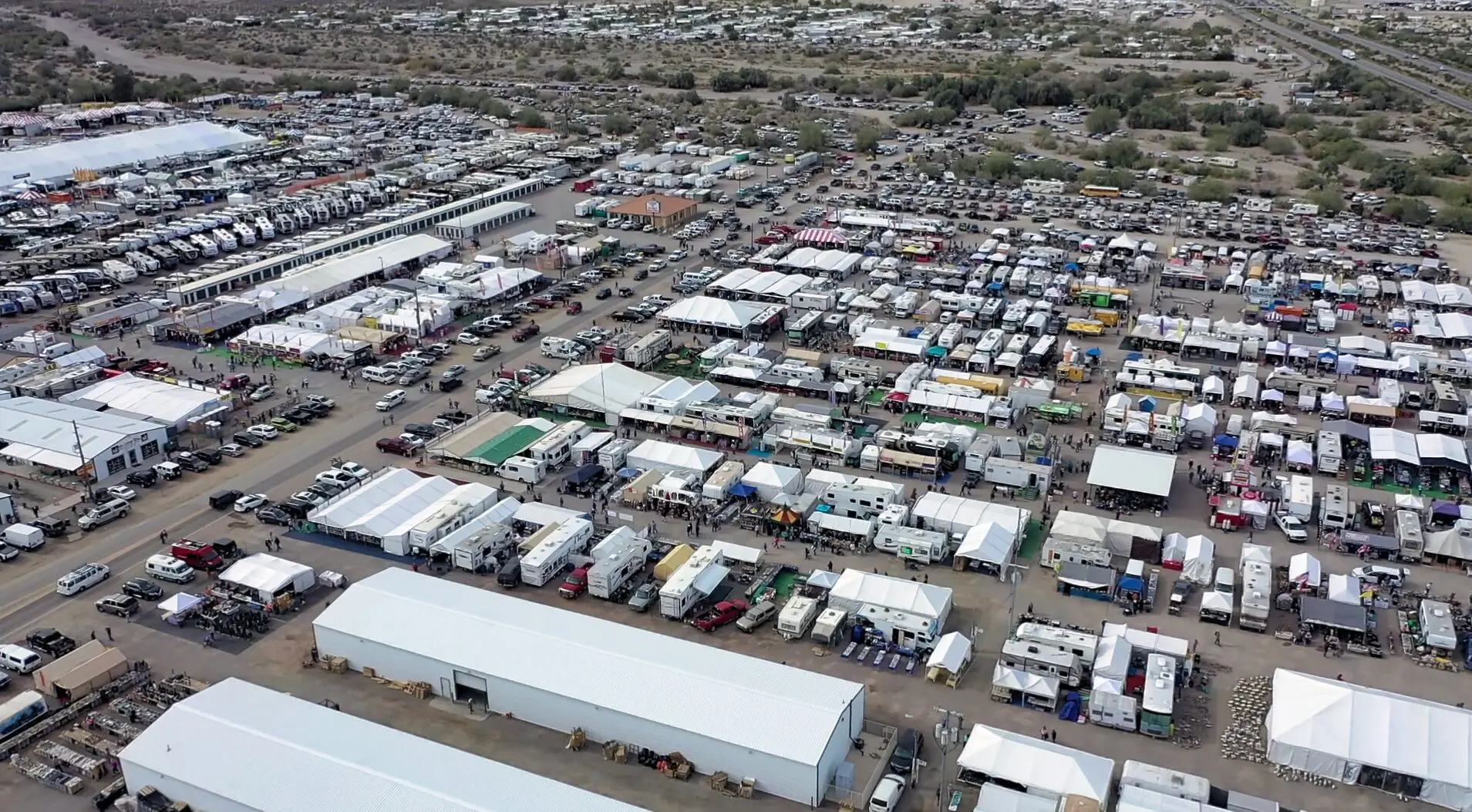 Aerial view of a large truck yard filled with many parked semi-trailers and trucks.
