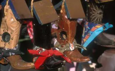 A rustic birdhouse with a red bow on a wooden base.