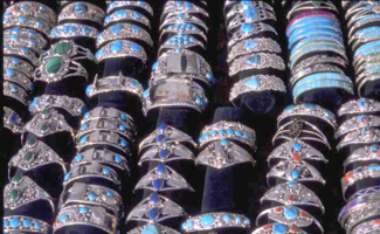 Rows of colorful rings on display at a market stall.